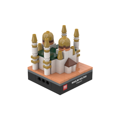 Masjid Sultan mini building blocks set, a desk-size Islamic collectible shown at an angle on white, featuring golden onion domes, white walls, gold-tipped minarets and a pitched entrance, set on a black DEENBLOCKS nameplate base