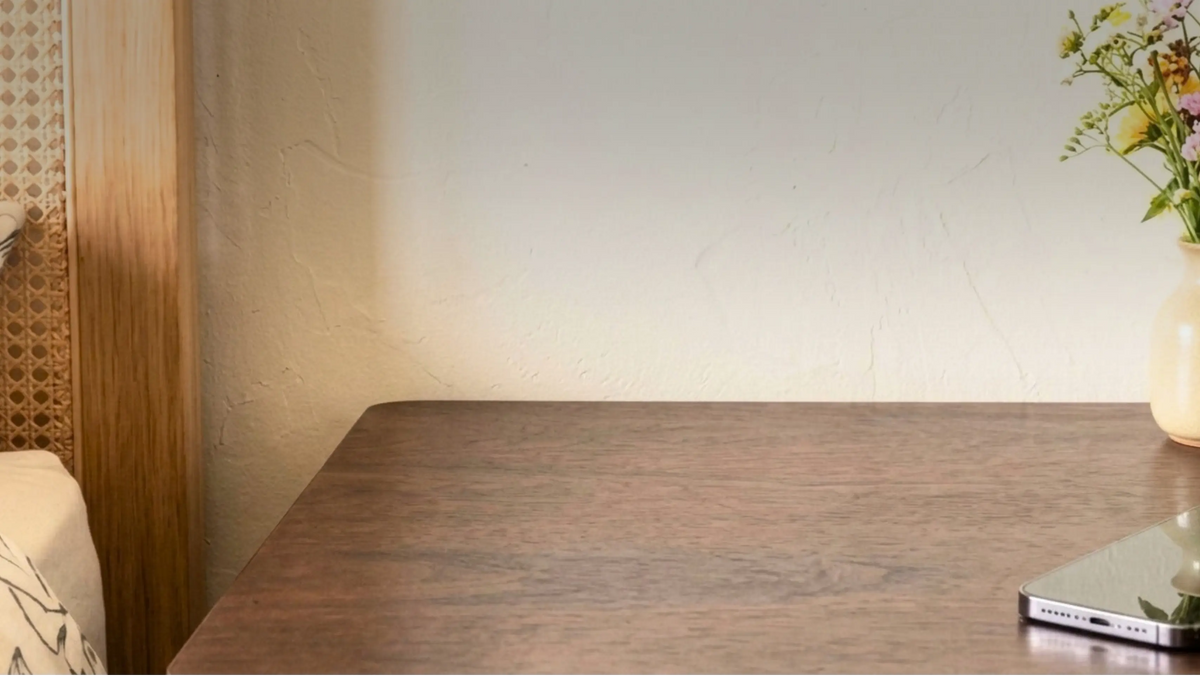 Dark wooden bedside table against a textured plaster wall with a phone at its edge, the bedside setting used to display a mini mosque building blocks model