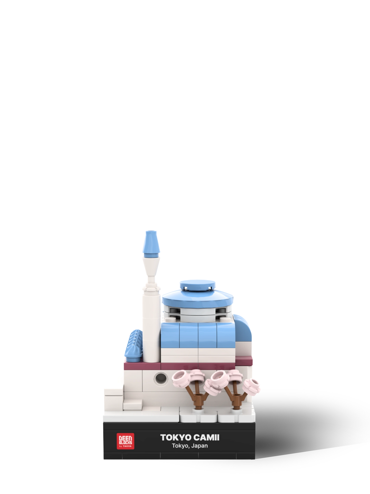 Front view of the Tokyo Camii mini mosque model in building blocks, with light blue domes, a white minaret and pink cherry blossom trees above a black nameplate reading Tokyo Camii, Tokyo, Japan